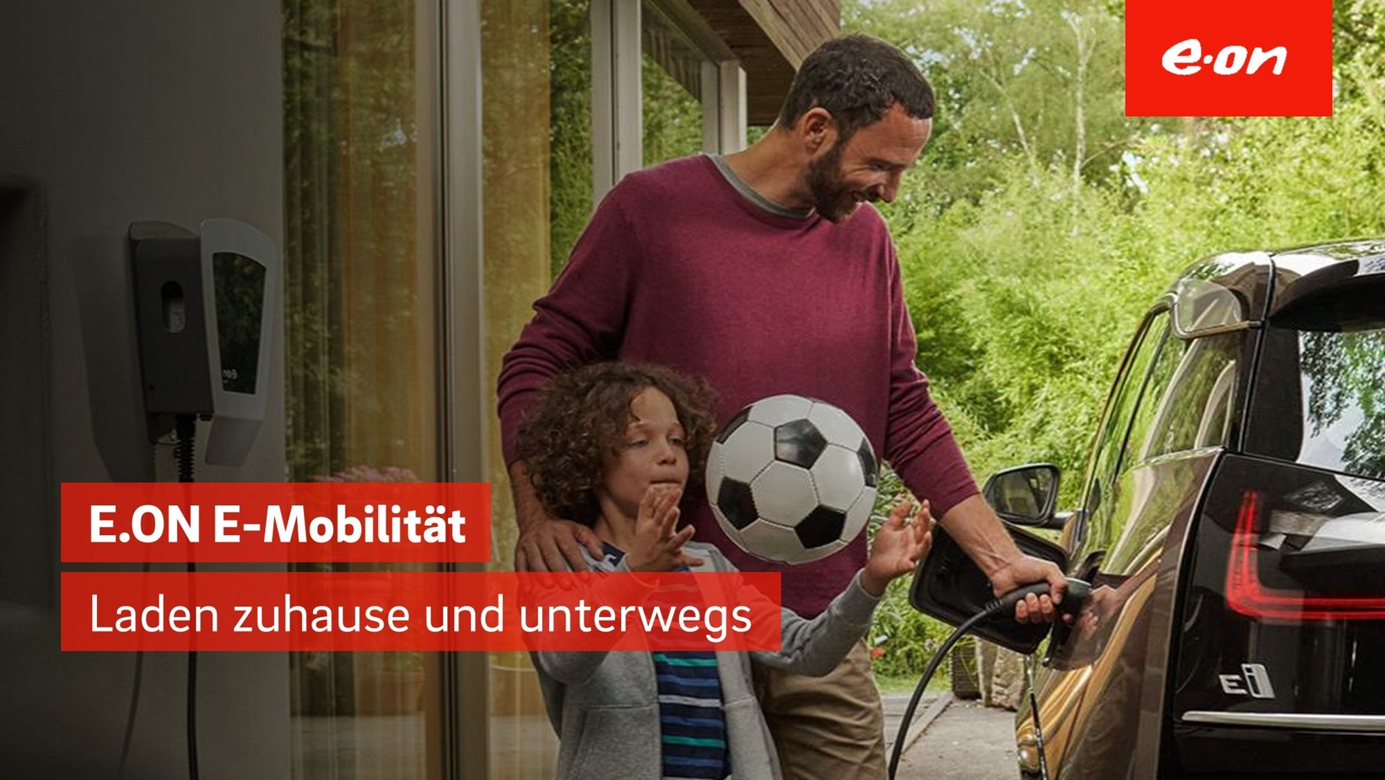 Vater lädt Elektroauto, Kind spielt