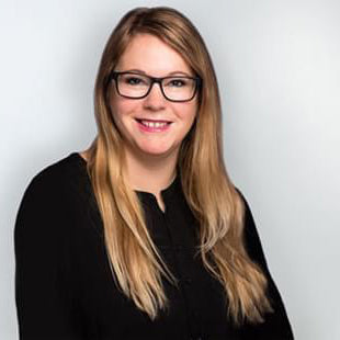 Businessfrau lächelt vor neutralem Hintergrund